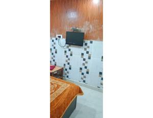 Habitación con cama y TV en la pared. en Hotel Rajratan, Kanpur, en Collectorganj