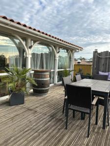 a patio with a table and chairs on a deck at Surf ou Golf House a quelques pas de l'océan in Moliets-et-Maa