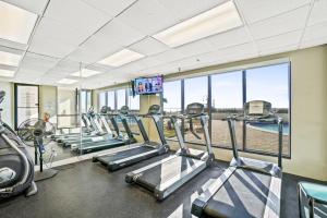 a gym with treadmills and a row of treadleys at Emerald Towers by Panhandle Getaways in Destin