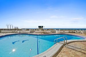 a large swimming pool with the ocean in the background at Emerald Towers by Panhandle Getaways in Destin +13 photos