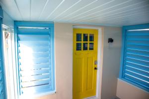 Habitación con puerta amarilla y ventana en Pet Friendly Half-Duplex, Cottage with 40' Slip Option at The Boat House Marina, en Marathon
