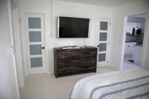 a bedroom with a flat screen tv on a wall at Pet Friendly Half-Duplex, Cottage with 40' Slip Option at The Boat House Marina in Marathon