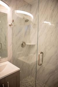 a shower with a glass door in a bathroom at Pet Friendly Half-Duplex, Cottage with 40' Slip Option at The Boat House Marina in Marathon