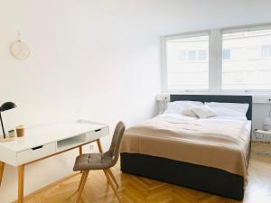 a bedroom with a bed and a desk and a chair at Ruhige Wohnung im Gasometer Wien *WIFI*U3*Netflix* in Vienna