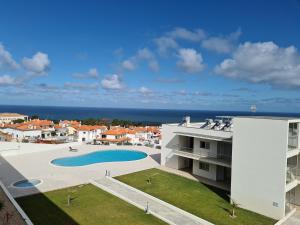 a view of a building with a swimming pool and the ocean at Cazenn Nazaré - Apartment Z in Nazaré