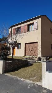 un edificio con un árbol delante de él en Formiguères Chalet 3 faces idéal famille en Formiguères