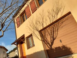 un edificio con una puerta de garaje y una sombra de árbol en Formiguères Chalet 3 faces idéal famille en Formiguères