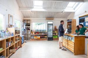 島上黑穆捷的住宿－Huttopia Noirmoutier，三人站在商店的柜台上
