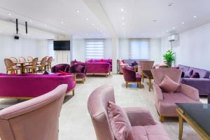 a waiting room with purple chairs and purple furniture at Hotel Mavi Deniz in Turunç