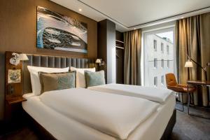 シュトゥットガルトにあるMotel One Stuttgart-Feuerbachの窓付きの客室で、白い大型ベッド1台が備わります。