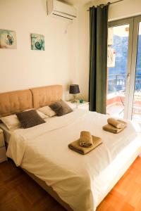 a bedroom with a large white bed with towels on it at Lavender Bay Apartments D3 or D5 in Donji Morinj
