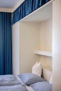 Garni Reider في سيستو: غرفة نوم بسريرين وستارة زرقاء