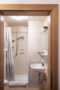 a bathroom with a shower and a sink and a toilet at Garni Reider in Sesto