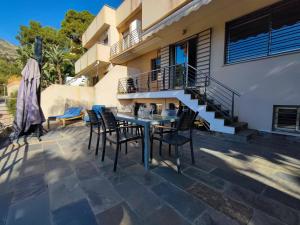 un patio con una mesa y sillas y una escalera en Villa Aguilas Club Guest house, en Málaga