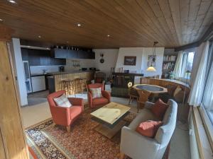a living room with a couch and chairs and a kitchen at Casa Sum Naul in Breil/Brigels