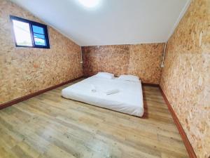 Baan PhakDeeChan في تشانتابوري: غرفة نوم بسرير في غرفة ذات أرضيات خشبية