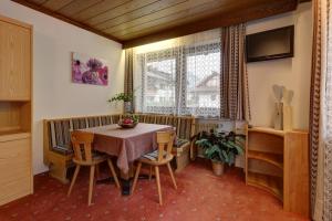 comedor con mesa, sillas y ventana en Appartements Hofer, en San Giacomo
