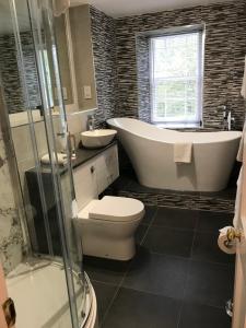 a bathroom with a tub and a toilet and a sink at Tullich House in Keith