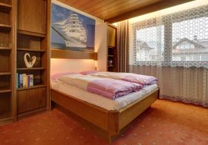 1 dormitorio con cama y ventana grande en Appartements Hofer, en San Giacomo