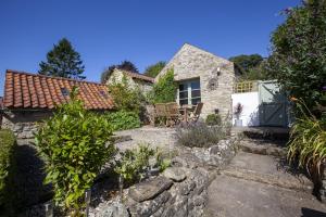 a stone house with a garden in front of it at Moorside Cottage in Ampleforth