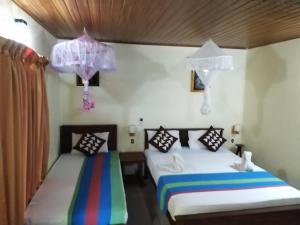 two beds in a room with at Gangula Eco lodge in Sigiriya