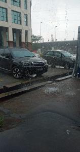 dos autos estacionados en un estacionamiento bajo la lluvia en รักหมดใจอพารทเมนต์, en Ban Khlong Nong Pru
