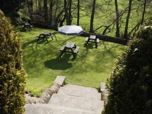 a park with picnic tables and a white tent at The Plough Inn in Hathersage