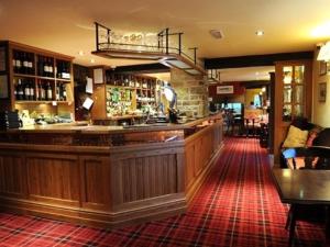 a bar in a pub with a red carpet at The Plough Inn in Hathersage