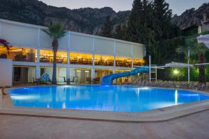 a large pool with a slide in front of a building at Hotel Mavi Deniz in Turunç