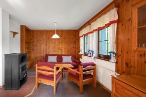 a living room with a table and chairs and a tv at Chalupy Na Rališce in Horní Bečva