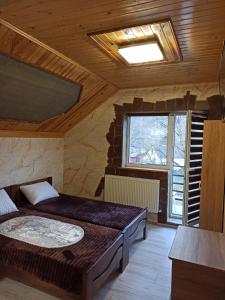 sypialnia z łóżkiem w pokoju z oknem w obiekcie Margo w Jaremczach
