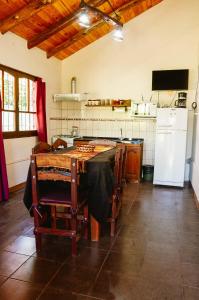 cocina con mesa y nevera blanca en Cabañas Huidun en San Rafael