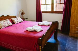 1 dormitorio con cama de madera y toallas en Cabañas Huidun en San Rafael