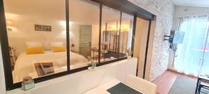 - une chambre avec un lit blanc et un grand miroir dans l'établissement appart central et son parking privatif gratuit, à Collioure