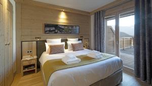 Un dormitorio con una cama grande con toallas. en MGM Hôtels & Résidences - Résidence Alpen Lodge, en La Rosière