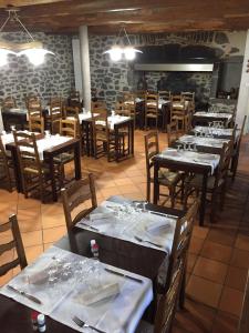 a dining room with tables and chairs with white table linen at Auberge Les Fontilles in Coltines