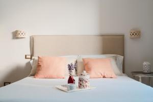 CursiにあるTenuta Donna Giulia SRLSの白いベッド(ピンクの枕付)、花のトレイ
