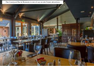 een restaurant met houten tafels en stoelen en wijnglazen bij Mains of Taymouth Country Estate 5* Gallops Apartments in Kenmore