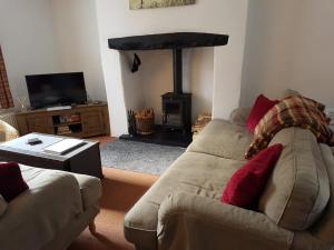 a living room with a couch and a fire place at Ty'n y Cwm, Nant Peris in Dinorwic