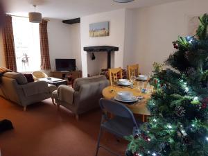 a living room with a christmas tree and a table at Ty'n y Cwm, Nant Peris in Dinorwic
