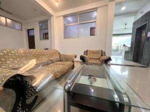 a living room with a couch and a glass table at Hotel Manikut in Rishīkesh