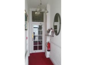 a hallway with a red carpet and a mirror at Diamonds Guest House in York