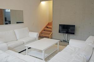 a living room with white couches and a tv at Nice summer house near the sea on Lidingo in Lidingö