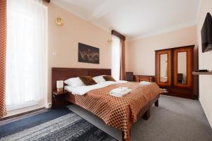 a bedroom with a bed and a large window at Hotel Roosevelt in Litoměřice