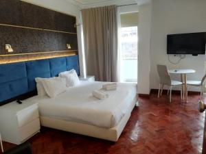 a hotel room with a large bed and a table at republica83-Lisbonhome in Lisbon