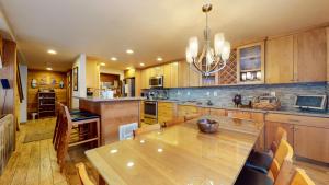 a kitchen with a wooden table and a dining room at Sierra Megeve #7 Condo in Mammoth Lakes +34 photos