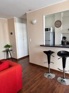 ein Wohnzimmer mit einem roten Sofa und einer Küche in der Unterkunft Departamento 2D 1B Lircay in Talca
