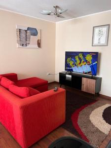 sala de estar con sofá rojo y TV en Departamento 2D 1B Lircay en Talca