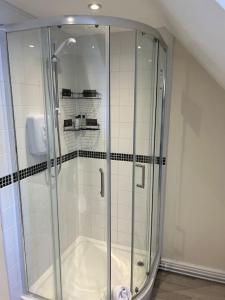 um chuveiro com uma porta de vidro na casa de banho em The Cottage, Watergate, Sleaford em Lincolnshire