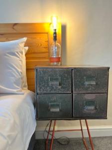 a nightstand with a lamp on it next to a bed at The Cottage, Watergate, Sleaford in Lincolnshire